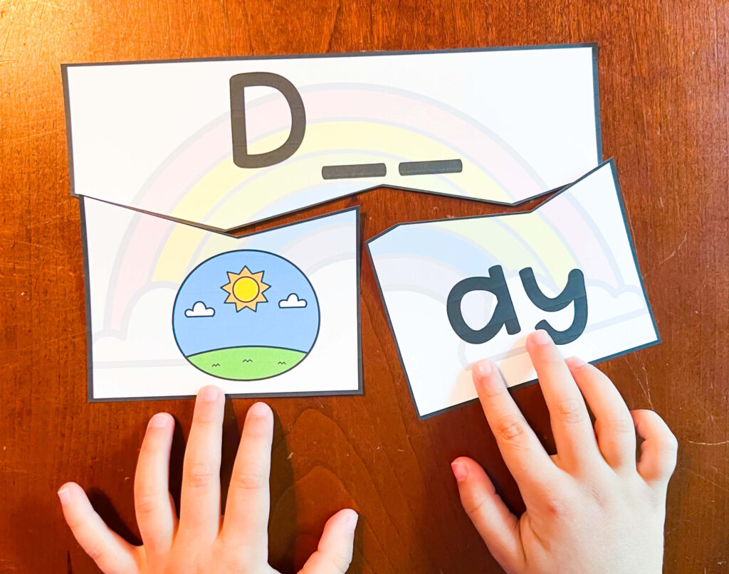 Image shows a child completeing a word ending puzzle for "day"