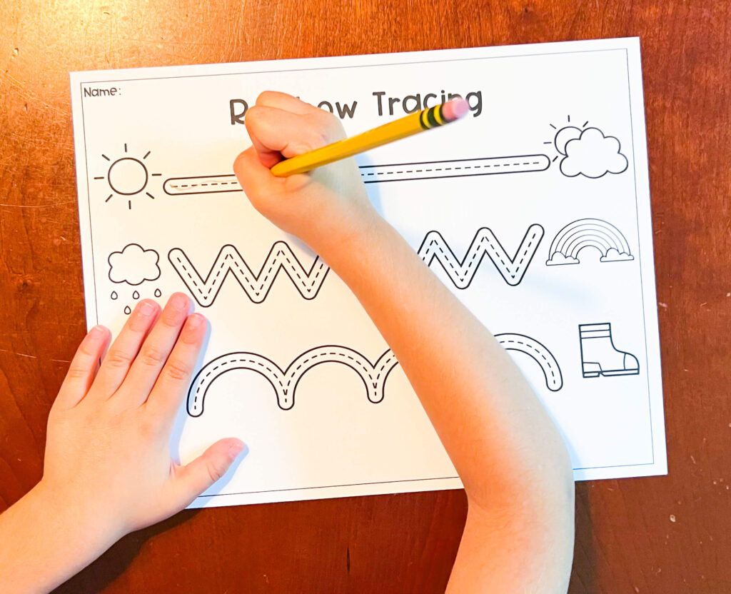 image shows a child tracing a line on a tracing worksheet