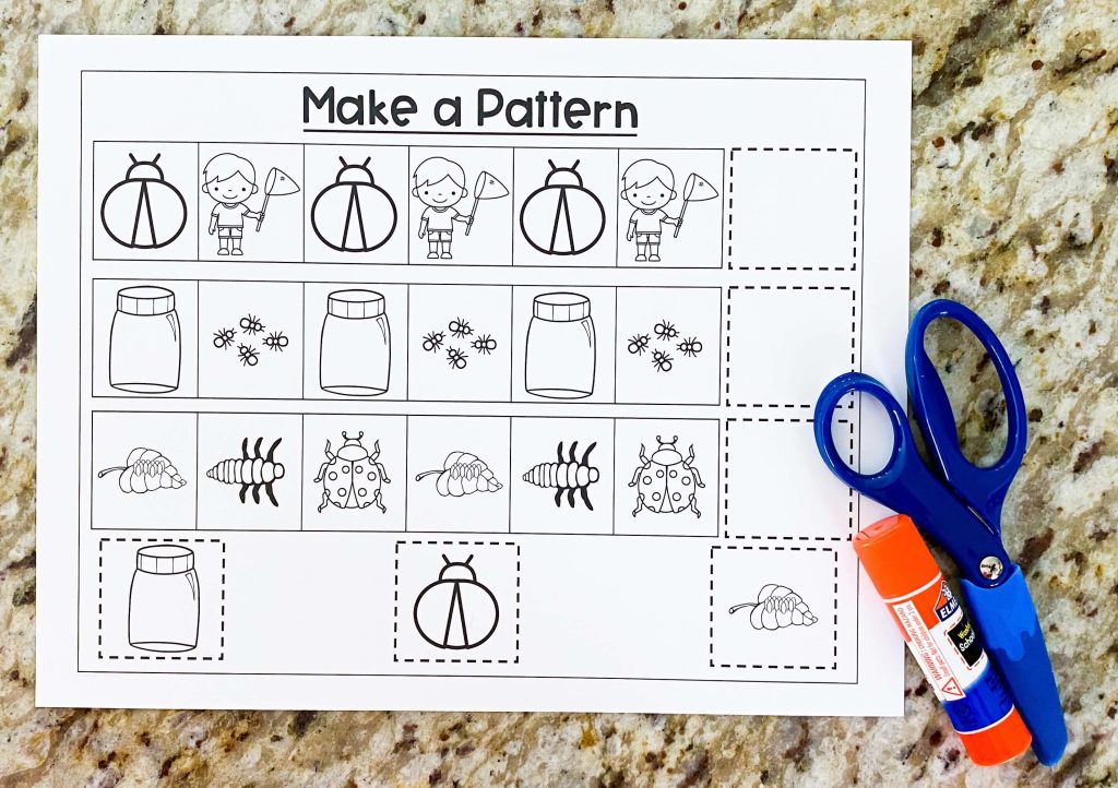 The image shows a worksheet with a pattern making on it.  There are scissors and a glue stick on the bottom corner.