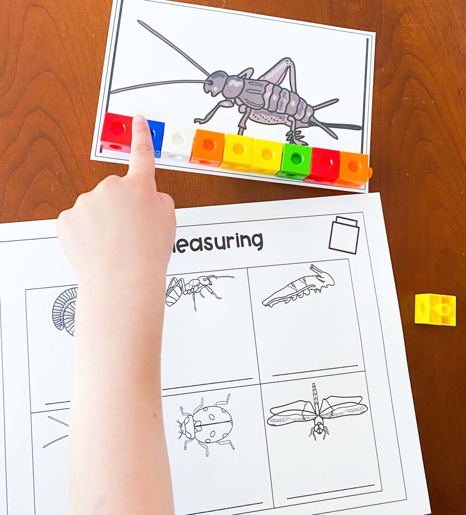 The image shows a child's hand counting the blocks that were used to measure the insect.  There is a recording sheet at the bottom of the image.